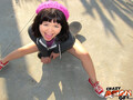 Xhivi kim sitting on pavement wearing pink hat in red sneakers