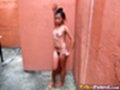 Standing naked against wall small tits natural bush hand on hip bare feet